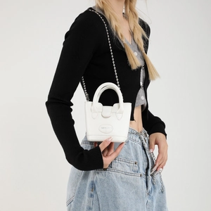 Weiße Mini-Beuteltasche für Damen mit Kettenschultergurt und Tragegriffen am Model