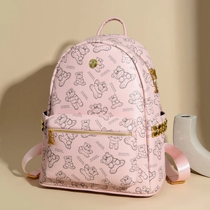 Détail du sac à dos en cuir rose avec imprimé ours cartoon et accents de rivets dorés