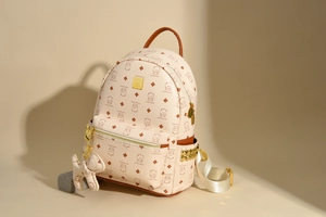 Details des beigen Vintage-Rucksacks mit Bärenprint, Goldnieten und Lederstruktur