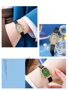 Detail view of oval gold watch dial with Roman numerals and emerald green face