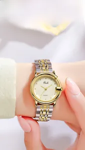 Detailed close-up of a Gedi quartz watch with a golden textured dial and G-shaped case