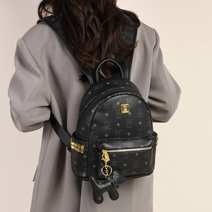 Sac à dos en cuir noir avec imprimé chat et détails dorés porté par un mannequin