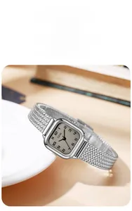 Close-up of vintage square silver watch with champagne dial and herringbone mesh strap