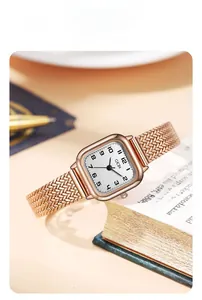Detailed close-up of a rose gold square dial watch with elegant wheat ear mesh strap