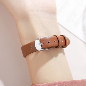 Elegant women's square watch featuring a brown leather strap and silver buckle on wrist