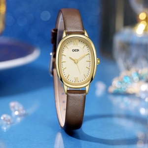 Elegant GEDI women's quartz watch with oval gold case and brown leather strap on blue background