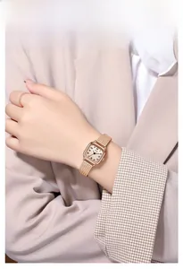 Close-up of a vintage square watch with rose gold mesh strap on a female wrist