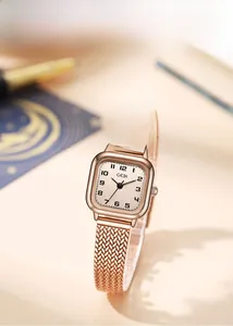 Close-up of a rose gold square vintage watch with a beige dial and mesh metal strap