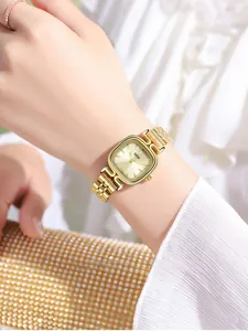Gros plan d'une montre carrée dorée avec cadran rayon de soleil et bracelet en métal