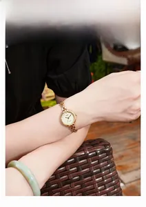 Dettaglio dell'orologio vintage dorato con quadrante strutturato e indici in diamante