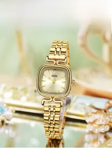 Gros plan d'une montre GEDI dorée avec cadran à texture soleil et bracelet métal