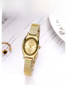 Detailaufnahme des goldenen ovalen Zifferblatts mit römischen Ziffern und Metallarmband