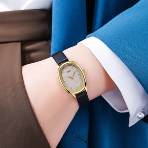 Detail view of the elegant oval gold case and black leather strap of the GEDI quartz watch