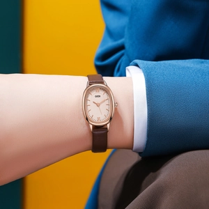 Detail view of GEDI oval watch with brown leather strap and rose gold Roman dial