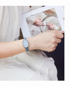 Detailed view of women's oval quartz watch with light blue leather strap and marble dial