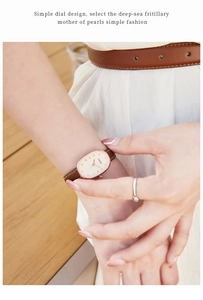 Close-up of elegant oval rose gold watch with mother-of-pearl dial and brown leather strap