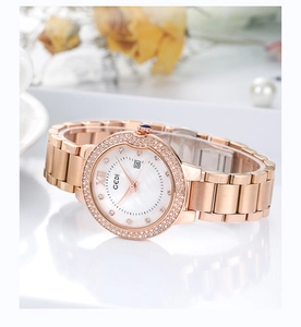 Macro detail of rose gold watch with sparkling rhinestone bezel and mother of pearl dial