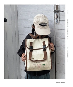 Detailed view of child wearing a vintage canvas backpack with cute cartoon animals