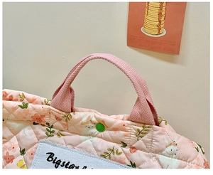 Detailansicht der gesteppten rosa Stofftasche mit weißen Hasen- und Blumenmustern