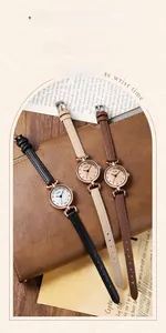 Detailed close-up of three elegant quartz watches with slim leather straps on vintage paper