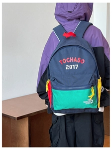 Dettaglio zaino per bambini con design a blocchi di colore e logo ricamato