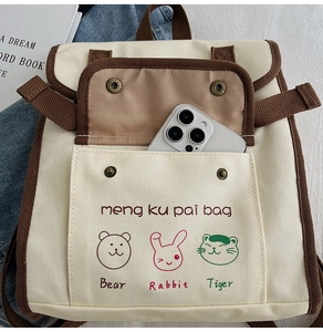 Detail of canvas backpack featuring cartoon animal prints and retro metal snap button