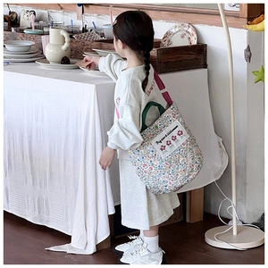 Detail der gesteppten Baumwolltasche mit Blumenmuster und bunten Riemen