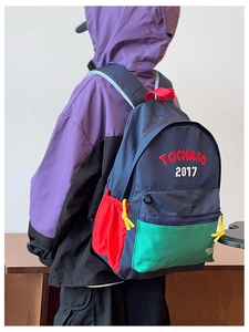 Dettaglio del tessuto in nylon color-block e dei loghi ricamati sullo zainetto per bambini