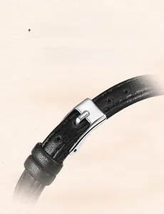 Detail of slim black leather watch strap with polished silver buckle and fine stitching