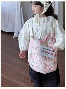 Mädchen trägt eine gesteppte Baumwolltasche mit Blumenmuster und Hasenmotiven