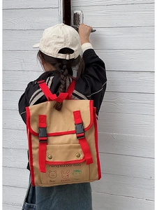 Detail of vintage canvas kids backpack with red trim and cute cartoon animal prints