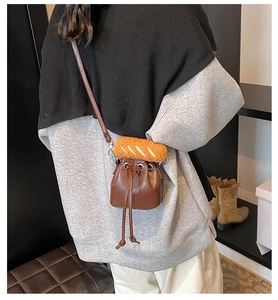 Detail of brown PU leather bucket bag with creative plush baguette bread charm