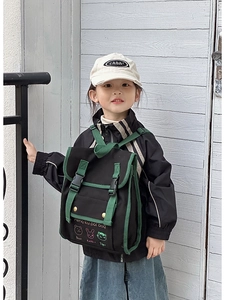 Detail of vintage canvas kids backpack with cartoon embroidery and retro green straps