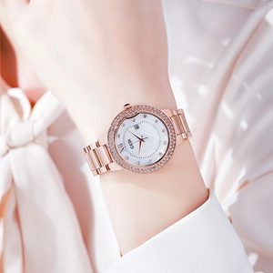 Rose gold watch with diamond bezel and white dial shown on a woman wrist