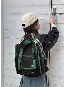 Detail showing cartoon animal print and retro green strap on black canvas kids backpack