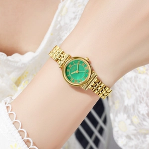 Close-up of elegant women's quartz watch with gold metal strap and green Roman dial
