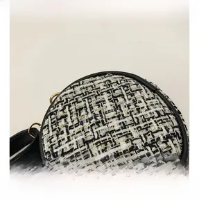 Close-up of tricolor tweed fabric texture and black leather piping on round bag