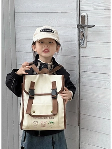 Detail of canvas kids backpack featuring cartoon animal prints and contrast piping