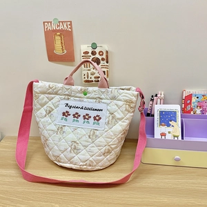 Detail der gesteppten Baumwolltasche mit Hasenstickerei und rosa Griffen