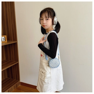 Detail of blue woven mini round crossbody bag for girls with adjustable shoulder strap