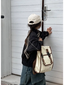 Detail of vintage canvas kids backpack with cartoon prints and secure buckle closure