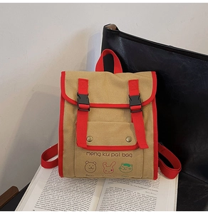 Detail of canvas kids backpack featuring khaki color with red straps and animal patterns