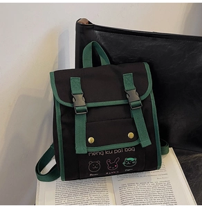 Close-up of student backpack with green straps and cute cartoon animal printing