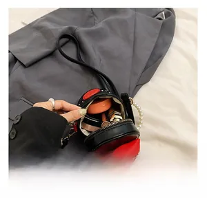 Internal capacity of mini black bucket bag with red bow and pearl chain handle