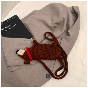 Detail der handgehäkelten Dackeltasche mit rotem Halsband und gewebtem Schultergurt