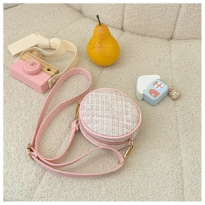 Close-up of pink and white tweed mini round crossbody bag with gold hardware for kids