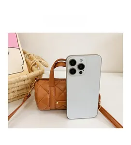 Nahaufnahme der braunen gesteppten Mini-Tasche im Größenvergleich zum Smartphone