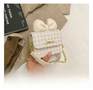 Detail showing tweed texture, leather bow, and gold 'Love' buckle on kids' crossbody bag