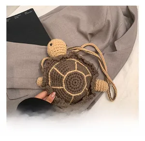 Detailed view of hand-knitted turtle-shaped kids crossbody bag in brown and beige