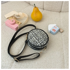 Close-up of black and white tweed mini round crossbody bag for girls with gold zipper